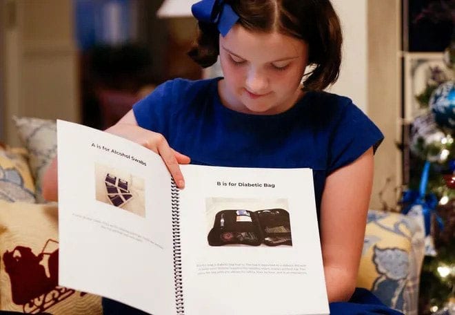 Sixth-grader Ellie Rowe, who has diabetes, shows a draft of her book that she originally wrote for a class project as a guide to managing the disease for kids. Rowe is now working with a publisher to bring the book to print.